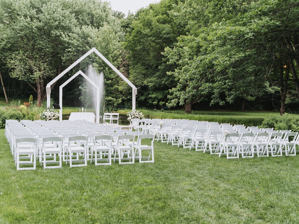 Chaises blanches et arche dans une prairie